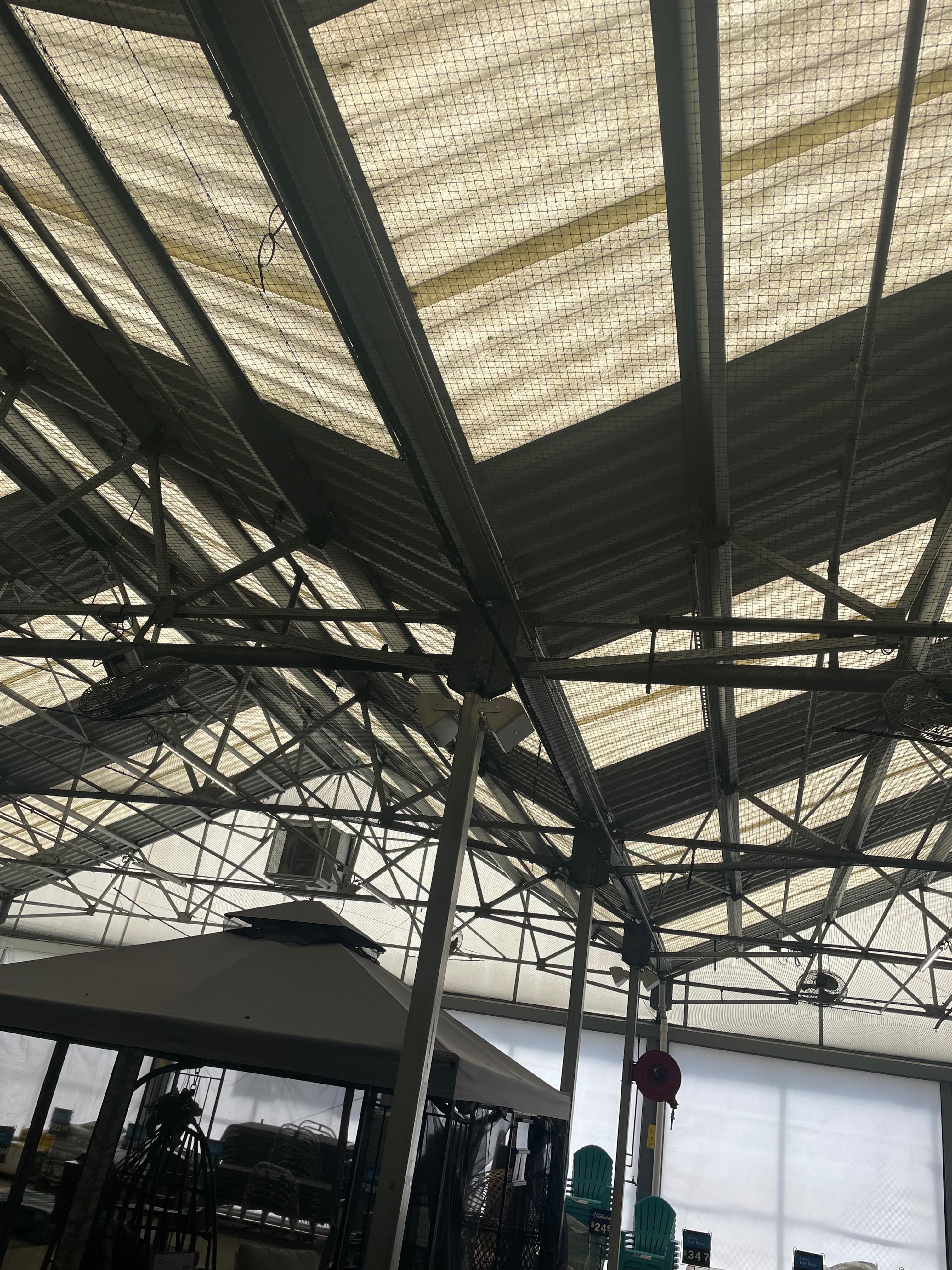Bird netting installation on industrial greenhouse structure
